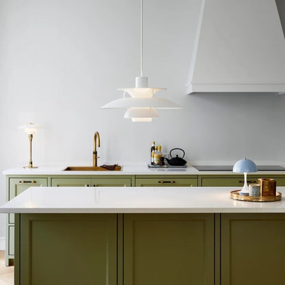 Suspension Dimoree Macaron blanche au design moderne installée au-dessus d'un îlot de cuisine vert