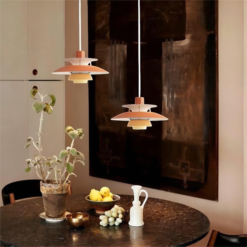 Deux suspensions Dimoree Macaron rose poudré au design moderne au-dessus d'une table à manger dans un intérieur élégant