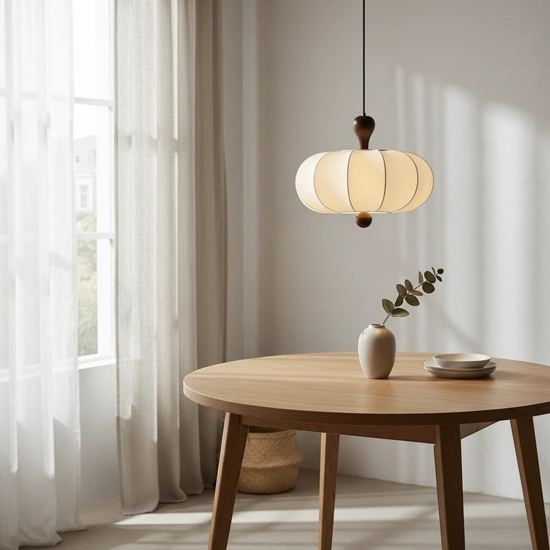 Suspension sculptée Dimoree blanche en tissu et bois de noyer au-dessus d'une table ronde en bois dans un salon