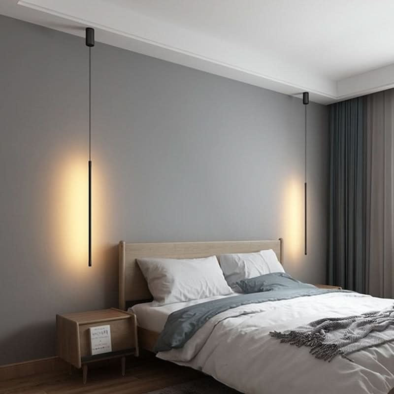 Suspension lumineuse tubulaire noire Dimoree au design minimaliste installée de chaque côté d'un lit dans une chambre.