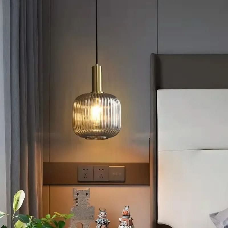 Suspension lumineuse Dimoree en verre nervuré fumé avec structure en métal doré brossé pour une ambiance élégante.