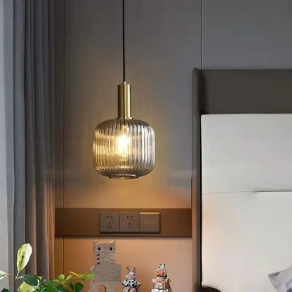 Suspension lumineuse Dimoree en verre nervuré fumé avec structure en métal doré brossé pour une ambiance élégante.